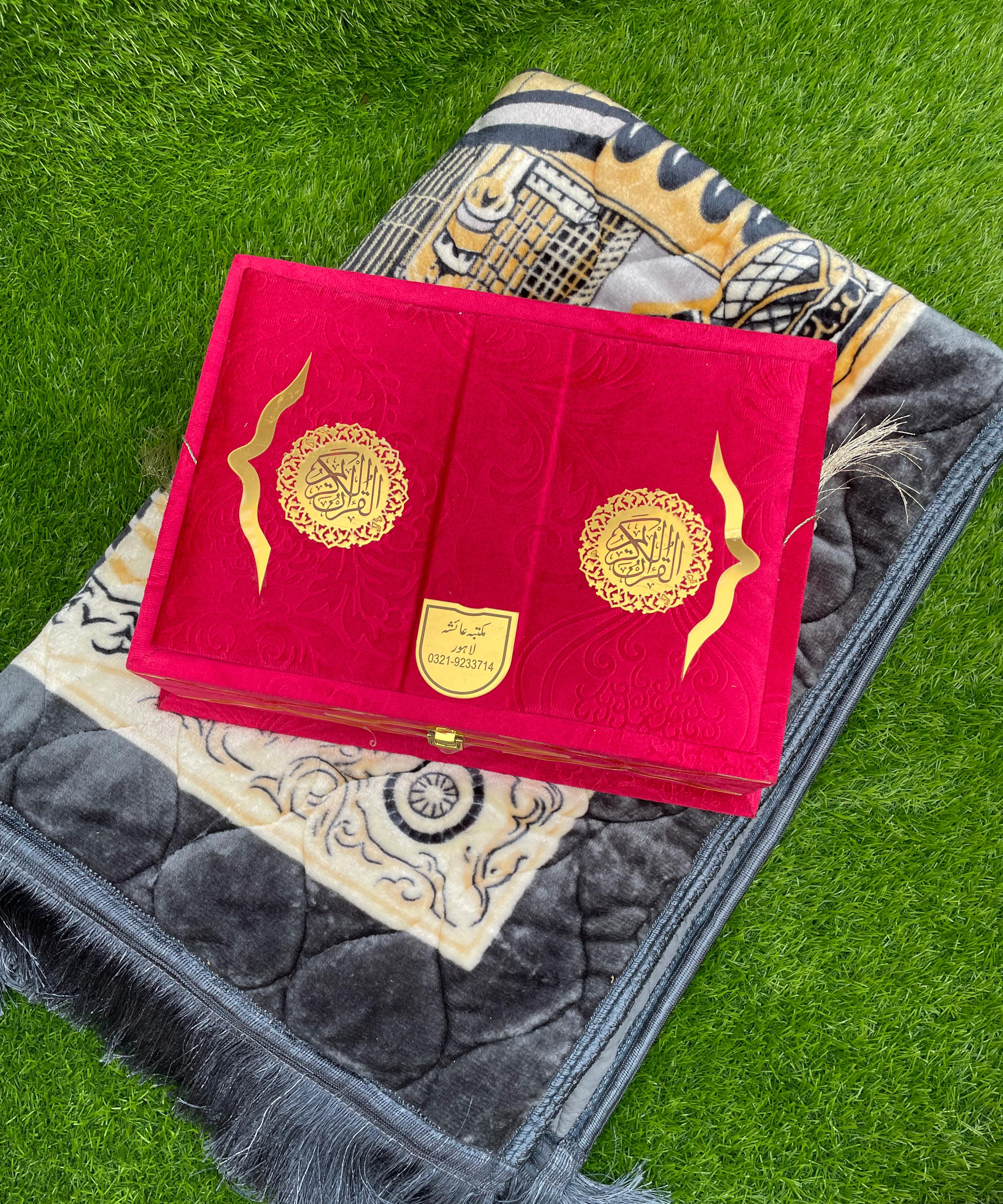 Red Quran GIft with gold designs on a prayer mat